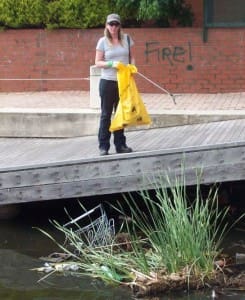 A Clean Up volunteer attempts to retrieve one of the many shopping trollies that litter the Lake