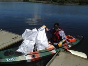 A volunteer collects rubbish from Lake Tuggeranong